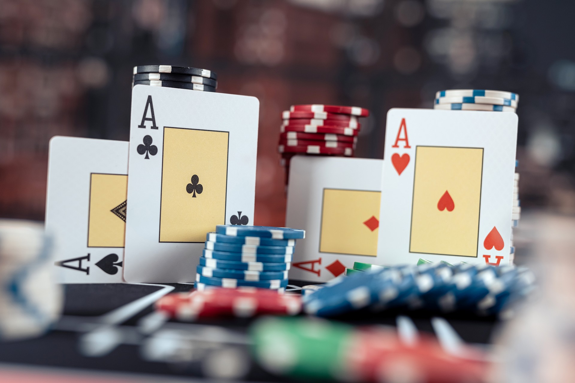 Poker playing four aces with stack of chips on the casino table